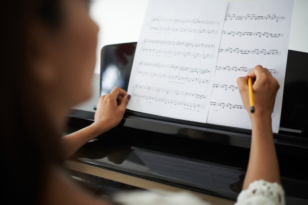 Woman marking up in music sheet before playing