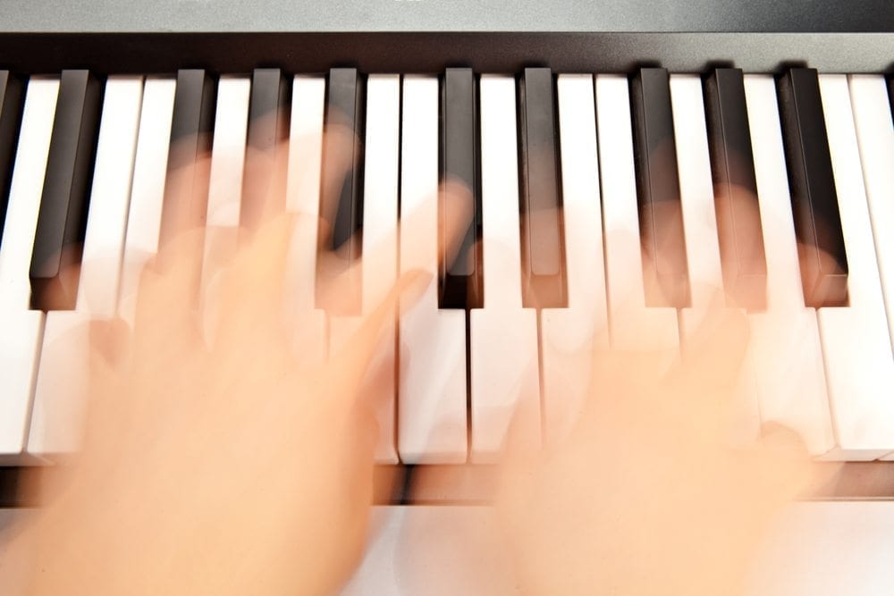 Hands playing the piano really fast