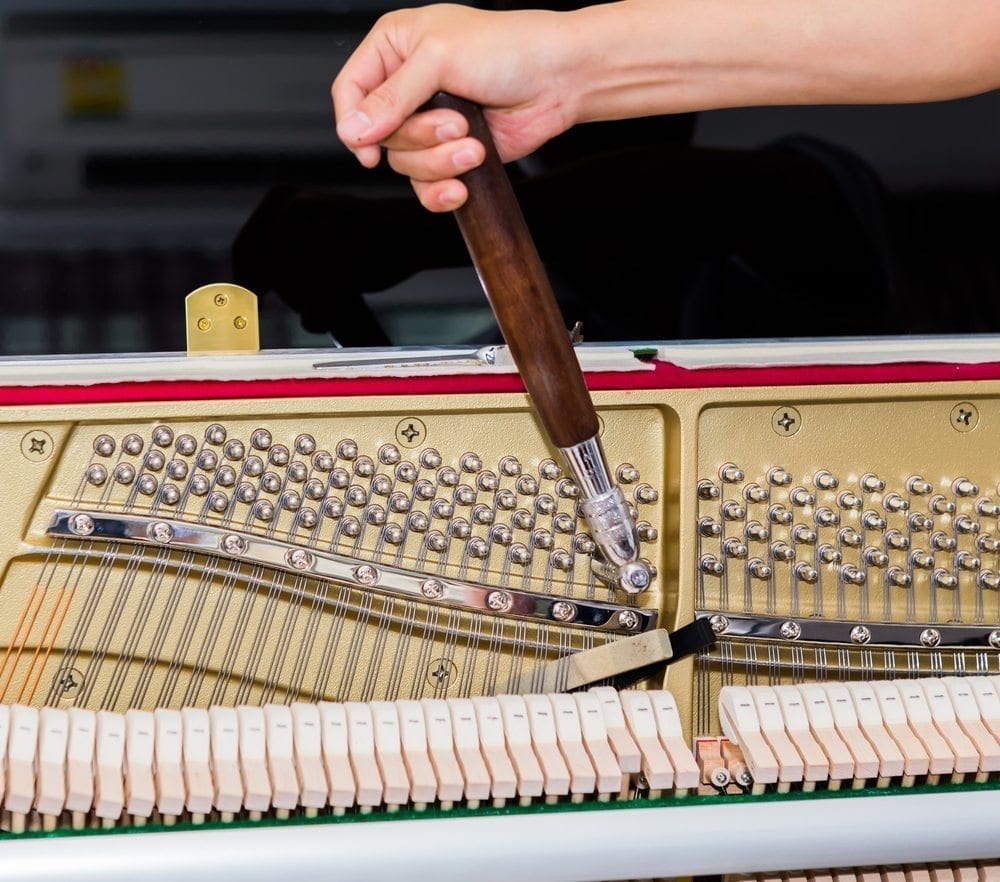 Person tuning a piano