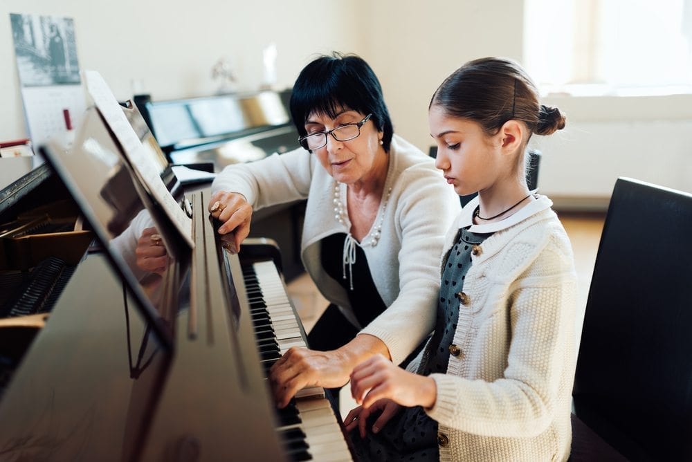 Piano teacher teaches girl