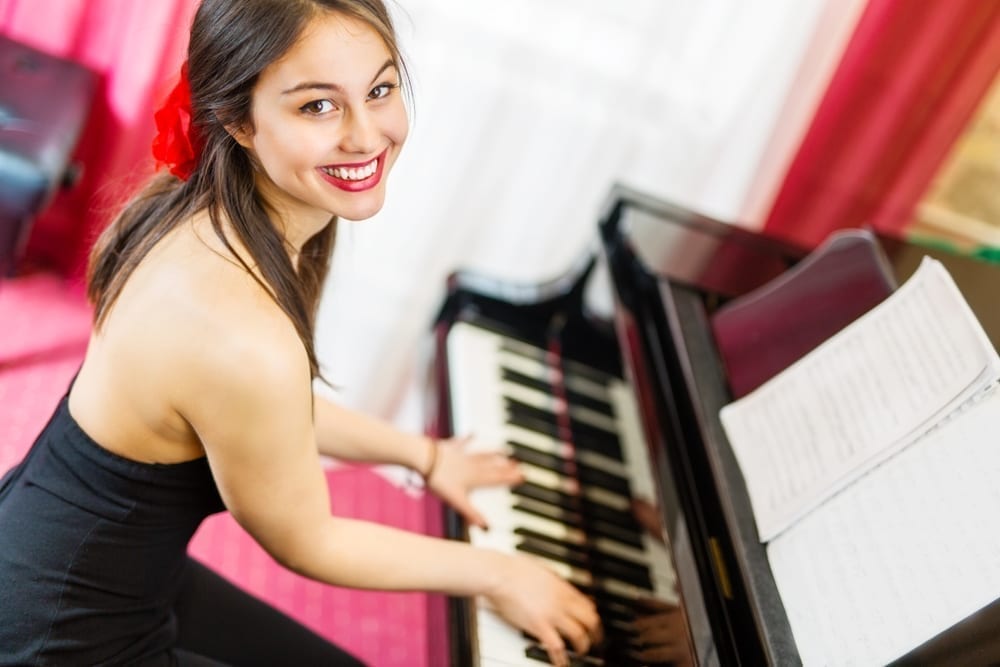 Young woman plays the piano