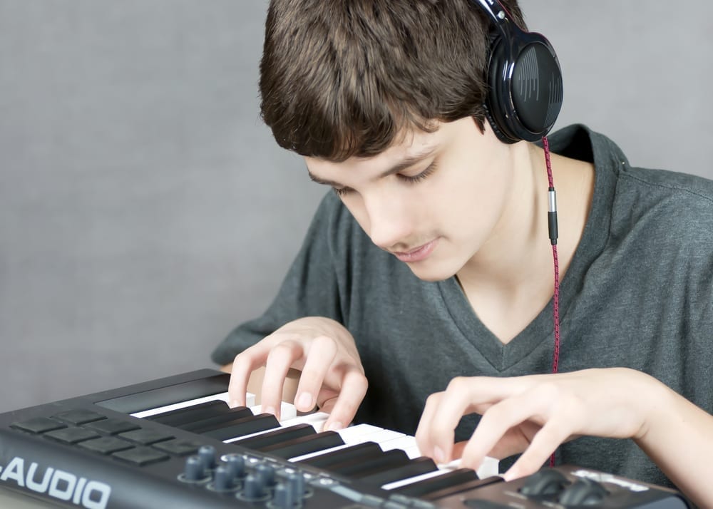 Close-up of a focused teen playing his keyboard