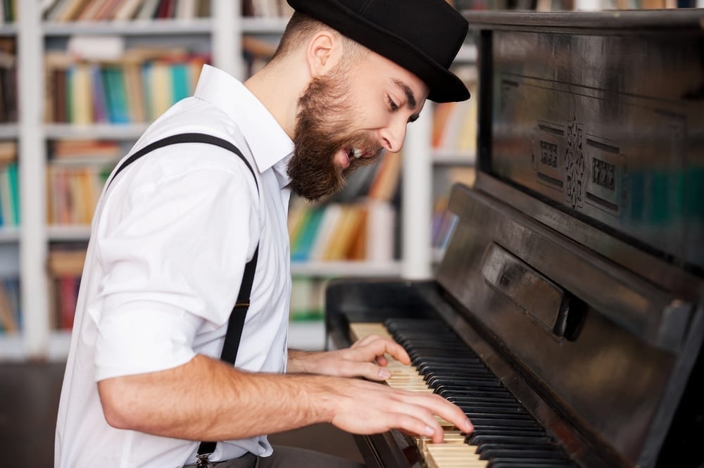 Young bearded men playing piano and singing