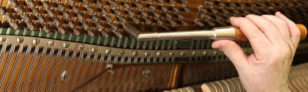 man tuning a piano