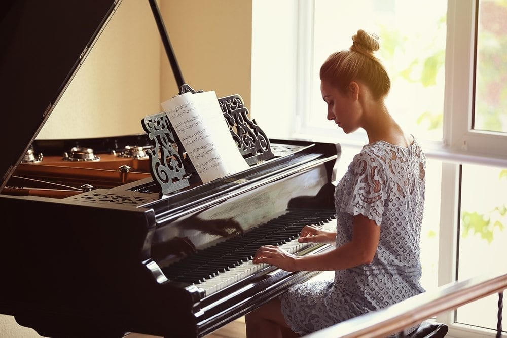 woman with head down playing piano