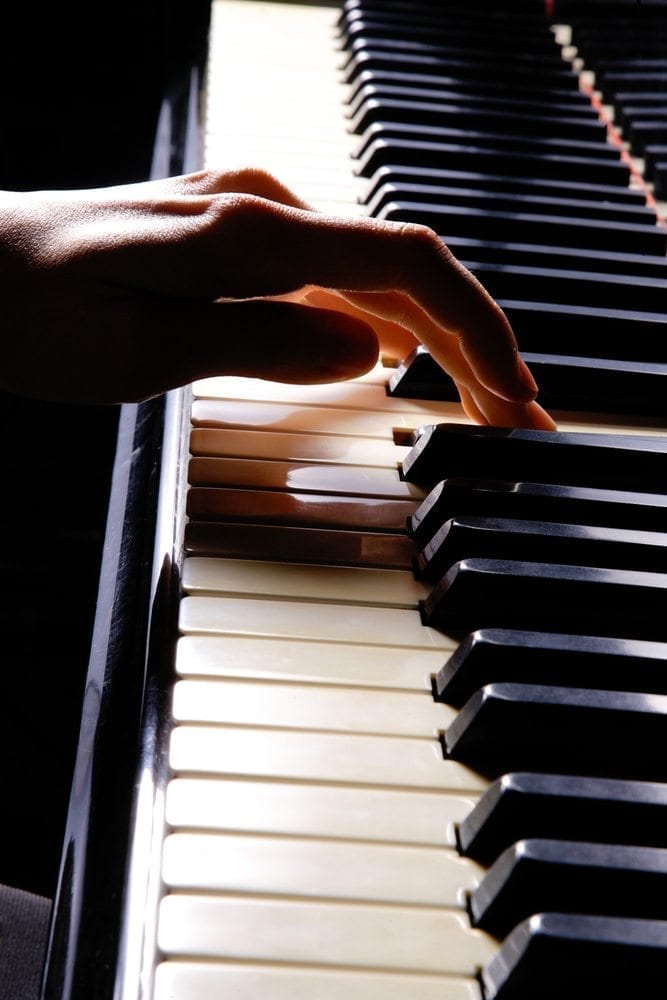 Close-up of young woman playing piano
